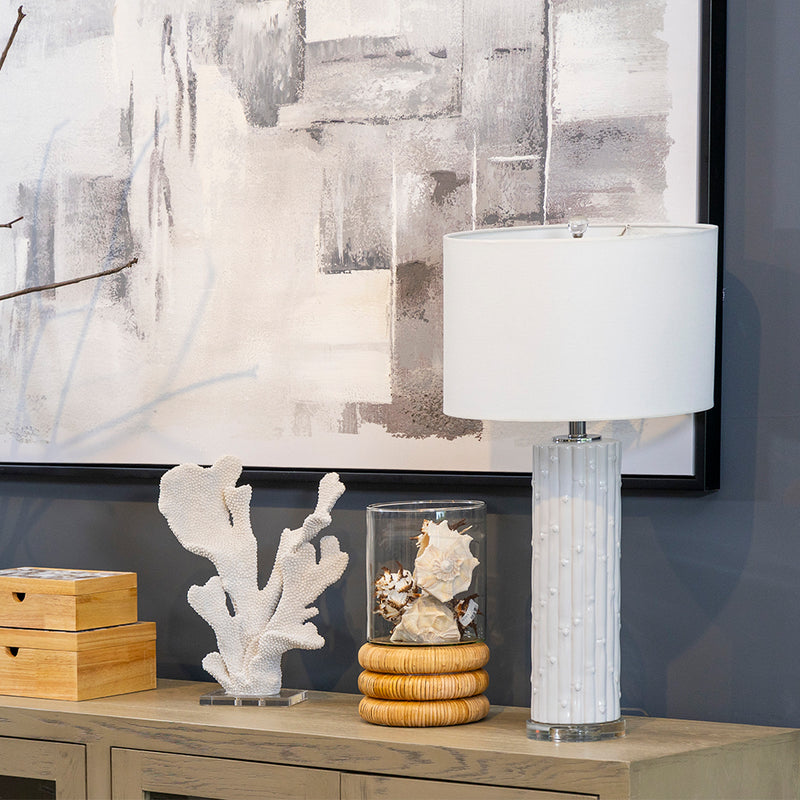 Lámpara Estriada de Cerámica Blanca, lámpara de líneas limpias, tonos monocromáticos, lámpara de loza cerámica, acero inoxidable, cobre, PVC, algodón y cristal acrílico, ofrece durabilidad, diseño refinado, lámpara de cuerpo cilíndrico texturizado, acabado blanco con detalles metálicos en plata, base de cristal transparente, pantalla blanca brillante, emite una luz cálida, armoniosa.