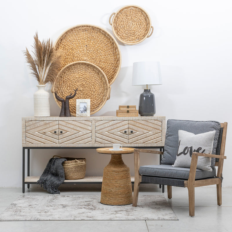 Mesa Lateral Tejida, Tablero de madera de caucho macizo, un marco de MDF recubierto con fibras vegetales secas y acentuada con detalles en hierro y metal negro.