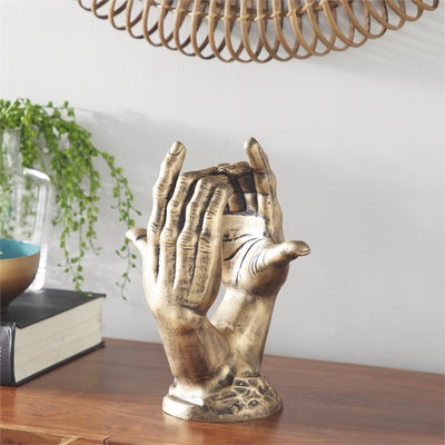 escultura de manos doradas